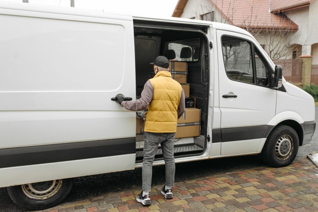 Chauffeur TRANSMALIN chargeant une fourgonnette de livraison
